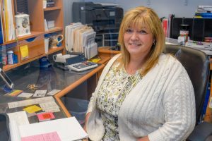 Security Water team member sits at desk and smiles for camera